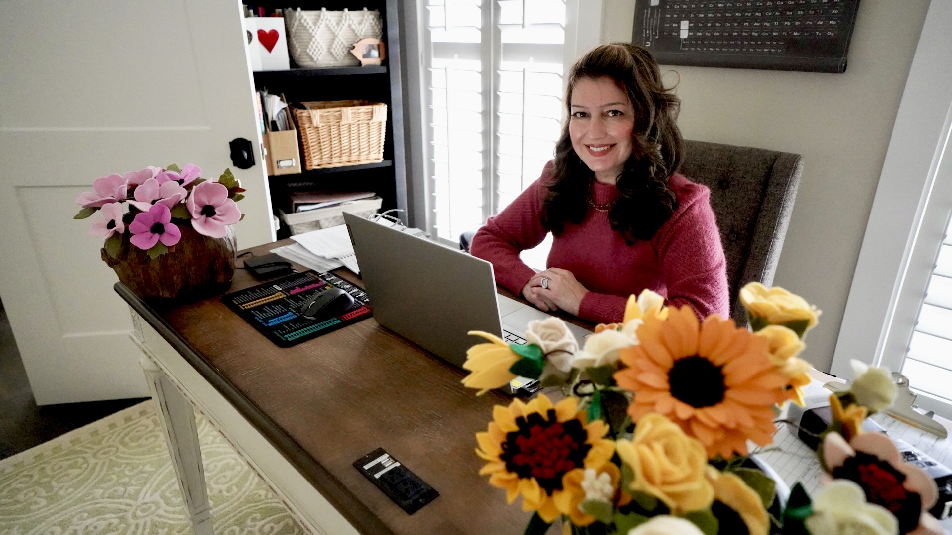 Rommie Oshrieh Neese posing for a photo at her desk.
